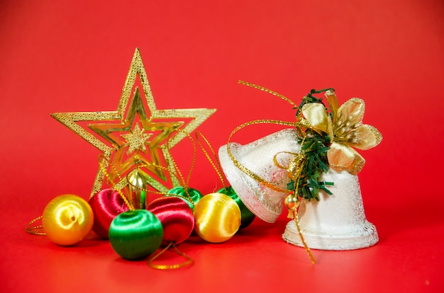 Foto gruppo di campana, palla e regalo di natale su sfondo rosso