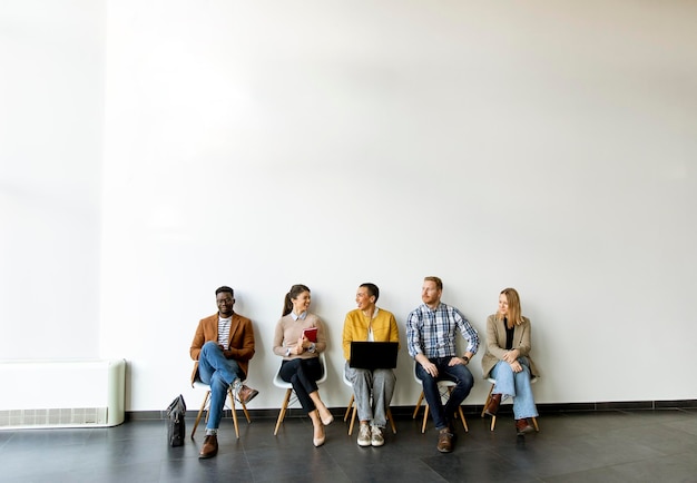 Photo group of bored young people waiting for the job interview