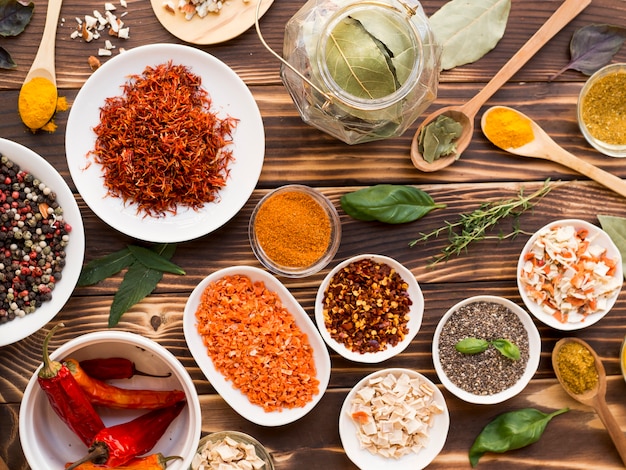 Group of bowls full of spices on wooden background