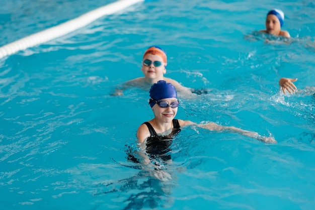 한 무리의 소년 소녀들이 현대식 수영장에서 놀고 수영을 배웁니다. 어린이 스포츠 개발 건강한 양육 및 어린이 스포츠 진흥