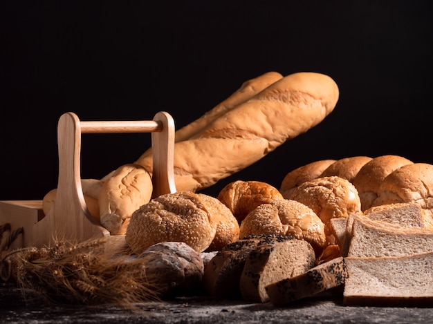 Foto un gruppo di pane sulla tavola di legno e sul nero