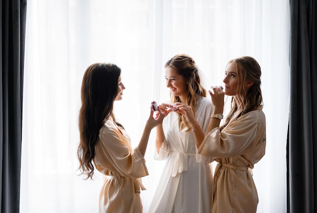 Photo group of bridesmaids with brides tasting sweets while preparing for engagement