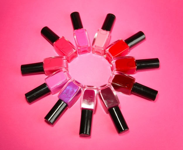 Group of bright nail polishes, on pink background