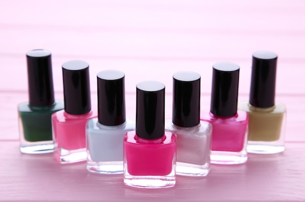 Group of bright nail polishes on pink