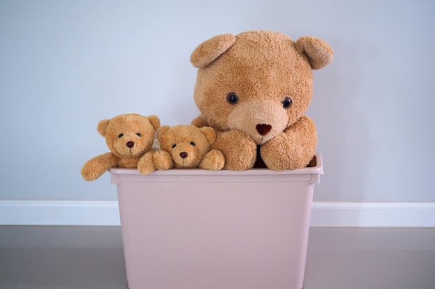 A group of brown-haired teddy bears in a pink box