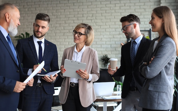 Group of business partners discussing ideas and planning work in office.