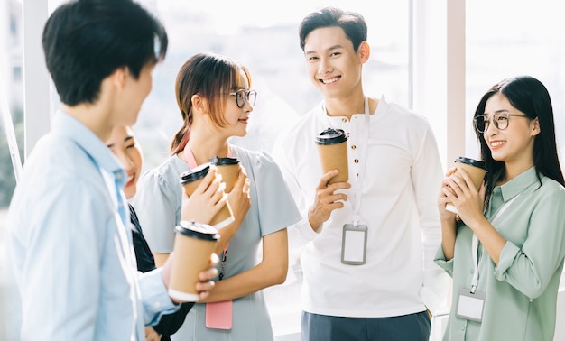 ビジネスマンのグループは休憩中にチャットやコーヒーを飲んでいます