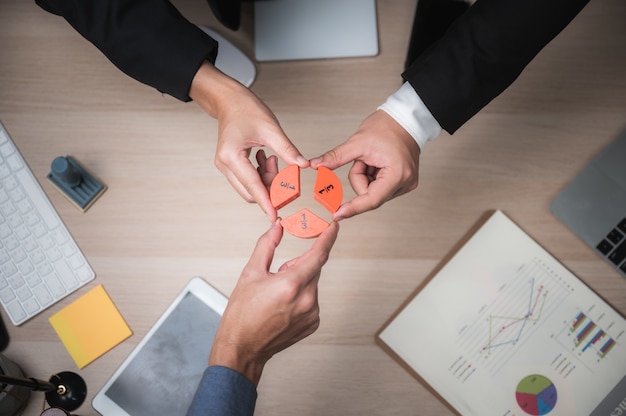 Group of business people assembling jigsaw puzzle and represent team support and help concept