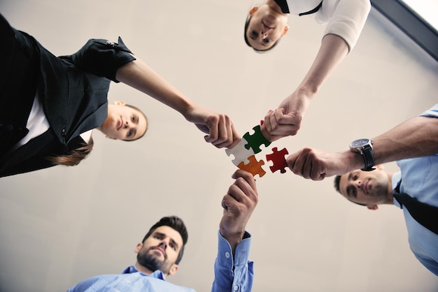 직소 퍼즐을 조립하고 팀 지원 및 도움말 개념을 대표하는 사업 사람들의 그룹
