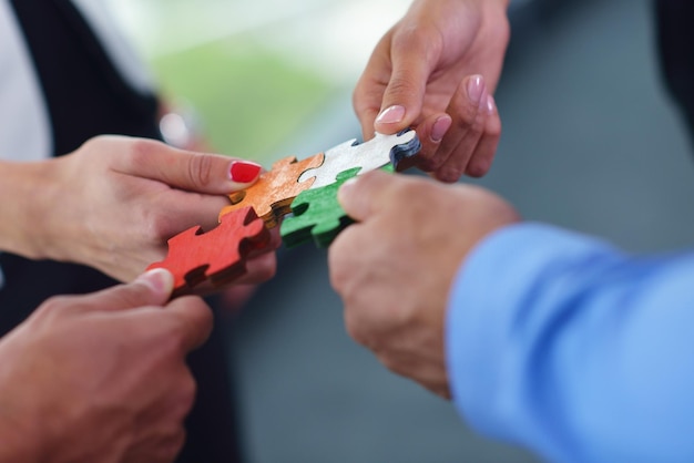 Photo group of business people assembling jigsaw puzzle and represent team support and help concept