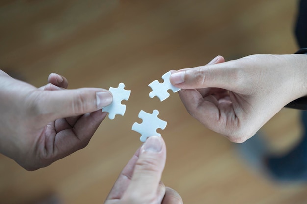 Group of business people assembling jigsaw puzzle and represent team support