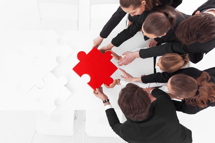 Group of business people assembling piece with jigsaw puzzle
