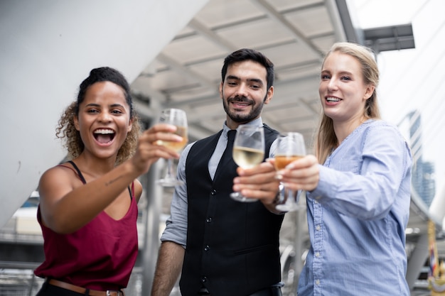 Group of business people celebrate by drinking wine.