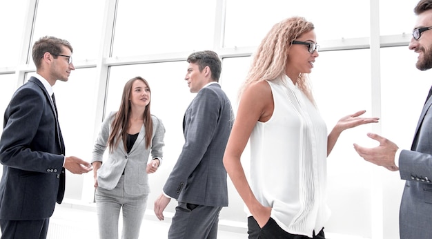 Group of business people discussing their ideas standing in an office hallway