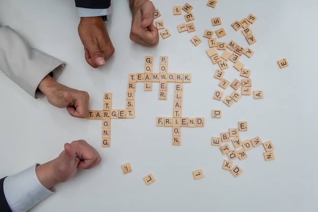 Group of business people hands thumbs up expressing teamwork with crossword puzzle words.