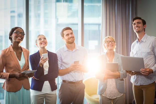 Group of business people holding mobile phone, digital tablet and laptop