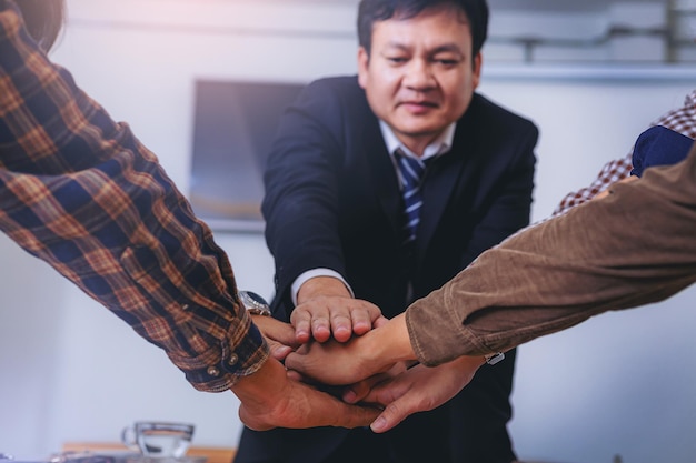 Group of business people join hands in office Teamwork together concept Selected focus