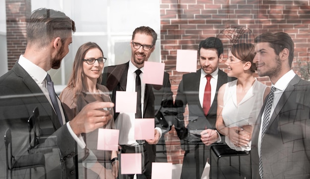 Group of business people looking at notes on glass