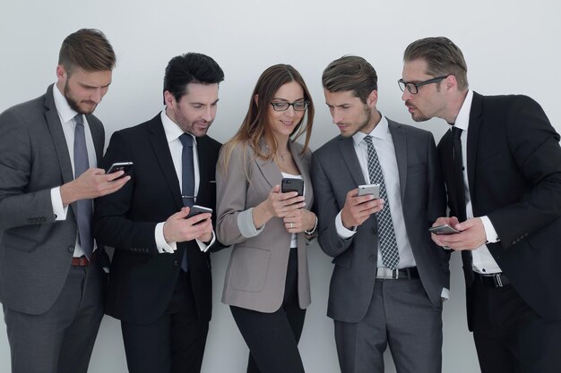 Group of business people looking at the screens of their smartphones people and technology