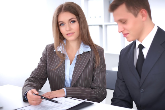 Group of business people at meeting. Focus on a beautiful brunette.