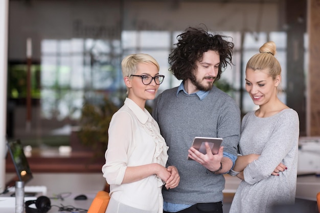 Gruppo di uomini d'affari che si preparano per il prossimo incontro e discutono di idee utilizzando la tavoletta digitale