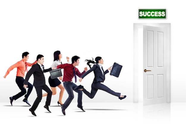 Group of business people run toward a success door