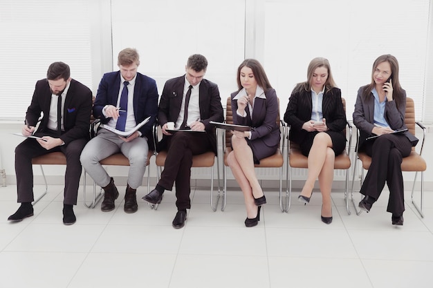 Group of business people sitting in the lobby before the\
interview