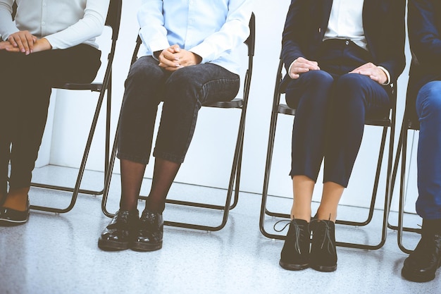 Group of business people sitting in office and waiting for job\
interview while using gadgets. conference or training\
concepts.