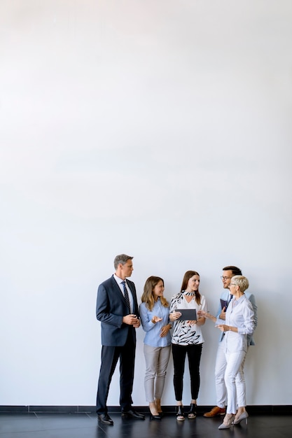 Group of business people standing by the wall in the office