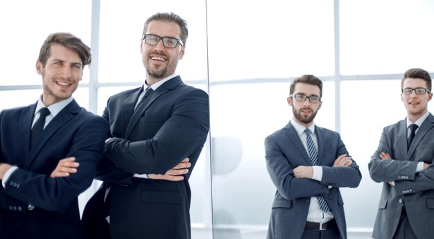 Group of business people standing near the glass wall photo with copy space