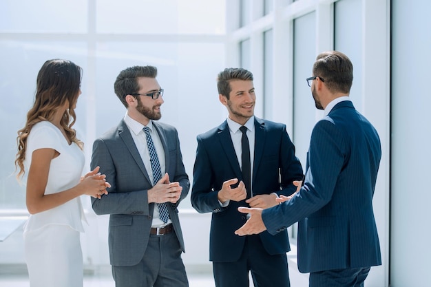 Gruppo di uomini d'affari che parlano in piedi nei giorni feriali dell'ufficio dell'ufficio