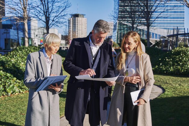 Group of business people walking outside in front of office buildings