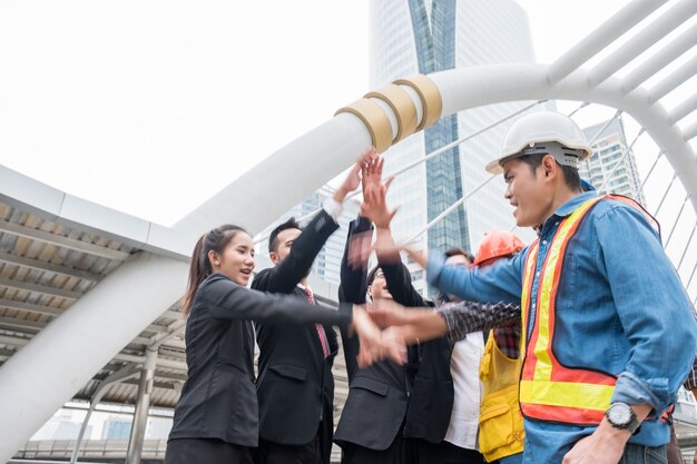 Group of business person with engineering partnership with hand raised up celebration of successful