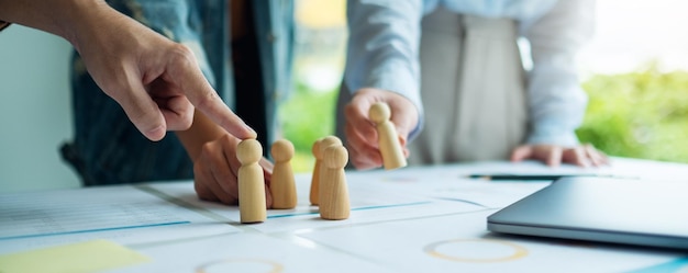 A group of business team brainstorming and planning strategy together with
wooden people in a meeting