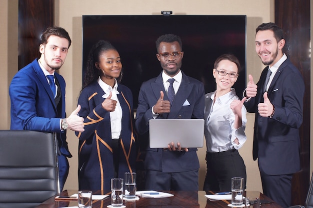 Group of Business team standing in conference room giving thumbs up while looking at camera