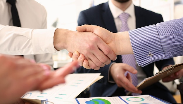 Photo group of businessmen shaking hands after productive meeting