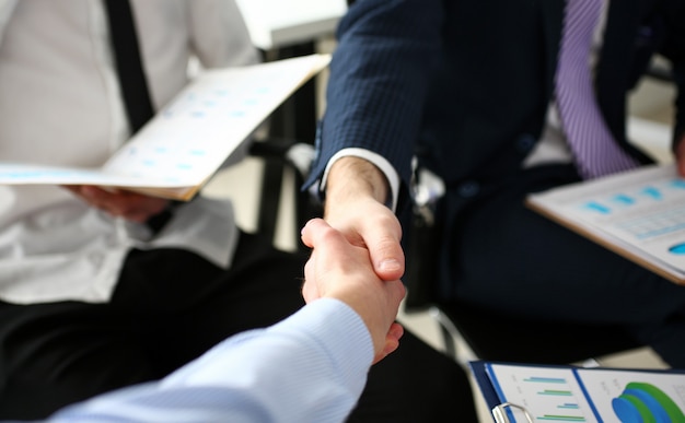 Group of businessmen shaking hands after productive meeting