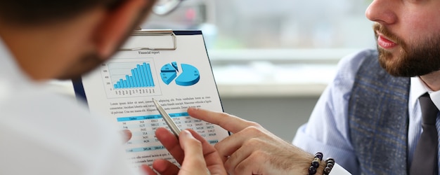 Group of businessmen with financial graph and silver pen