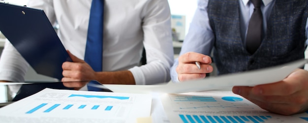 Group of businessmen with financial graph and silver pen