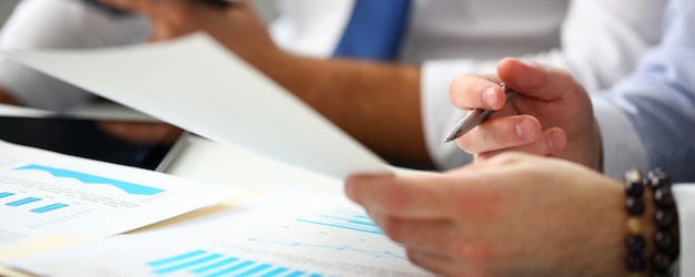 Group of businessmen with financial graph and silver pen