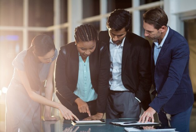 Group of businesspeople discussing together over digital tablet