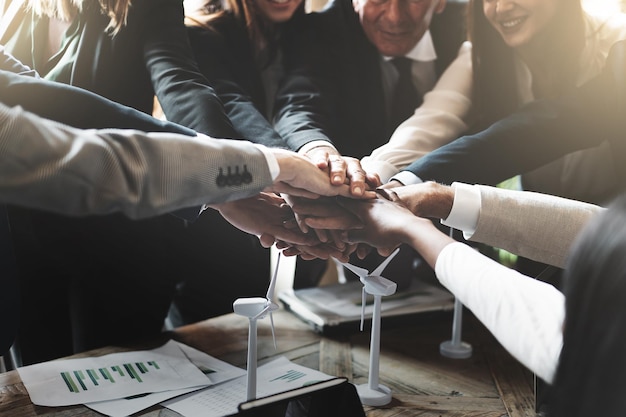 Foto un gruppo di uomini d'affari si unisce al progetto di energia eolica rinnovabile per celebrare il successo della squadra