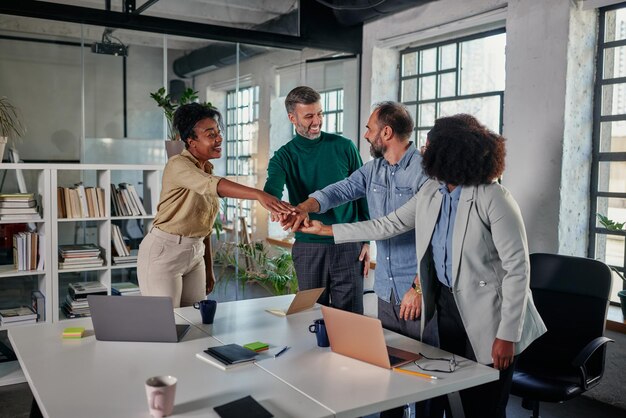 Group of businesspeople putting their hands together in unity