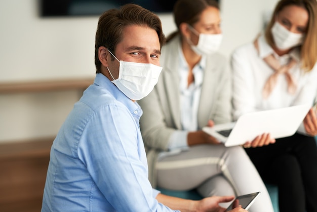 group of businesspeople working in protective masks