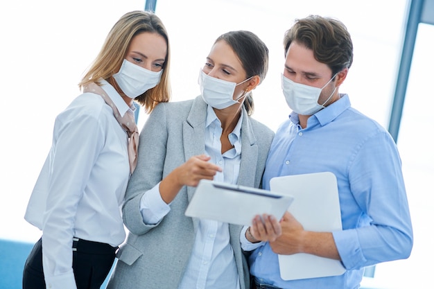 Foto gruppo di uomini d'affari che lavorano con maschere protettive