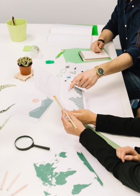 Group of businesspeople working together on graph over desk