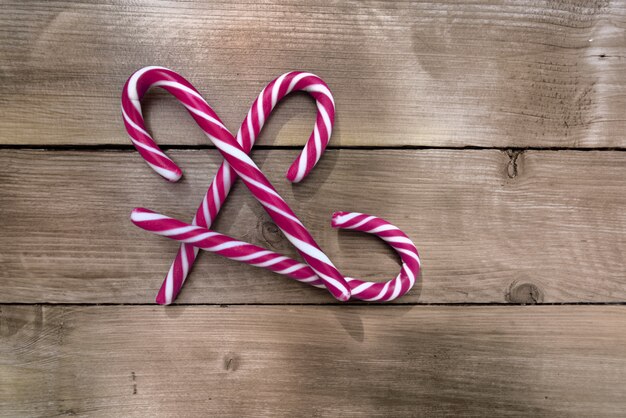 Group of candy canes on a rustic wooden planks 