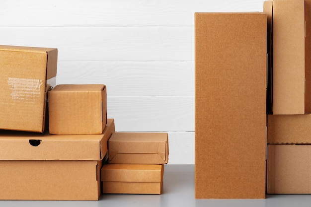 Group of cardboard boxes against white wooden wall