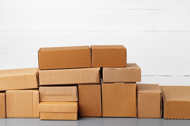 Group of cardboard boxes against white wooden wall