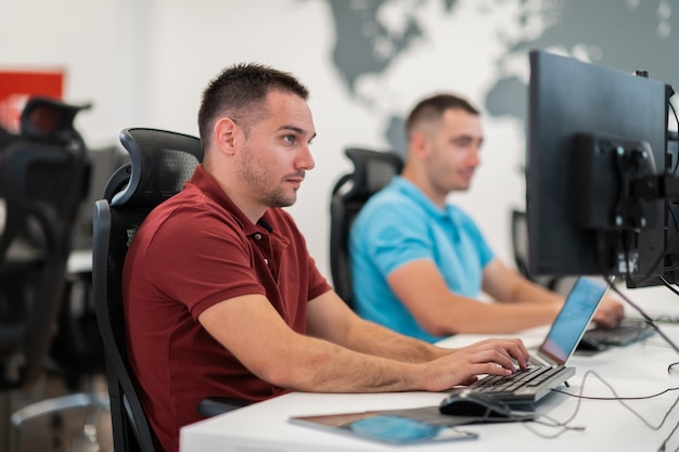 Group of casual businessmen working on a desktop computer in
modern open plan startup office interior. selective focus.
high-quality photo